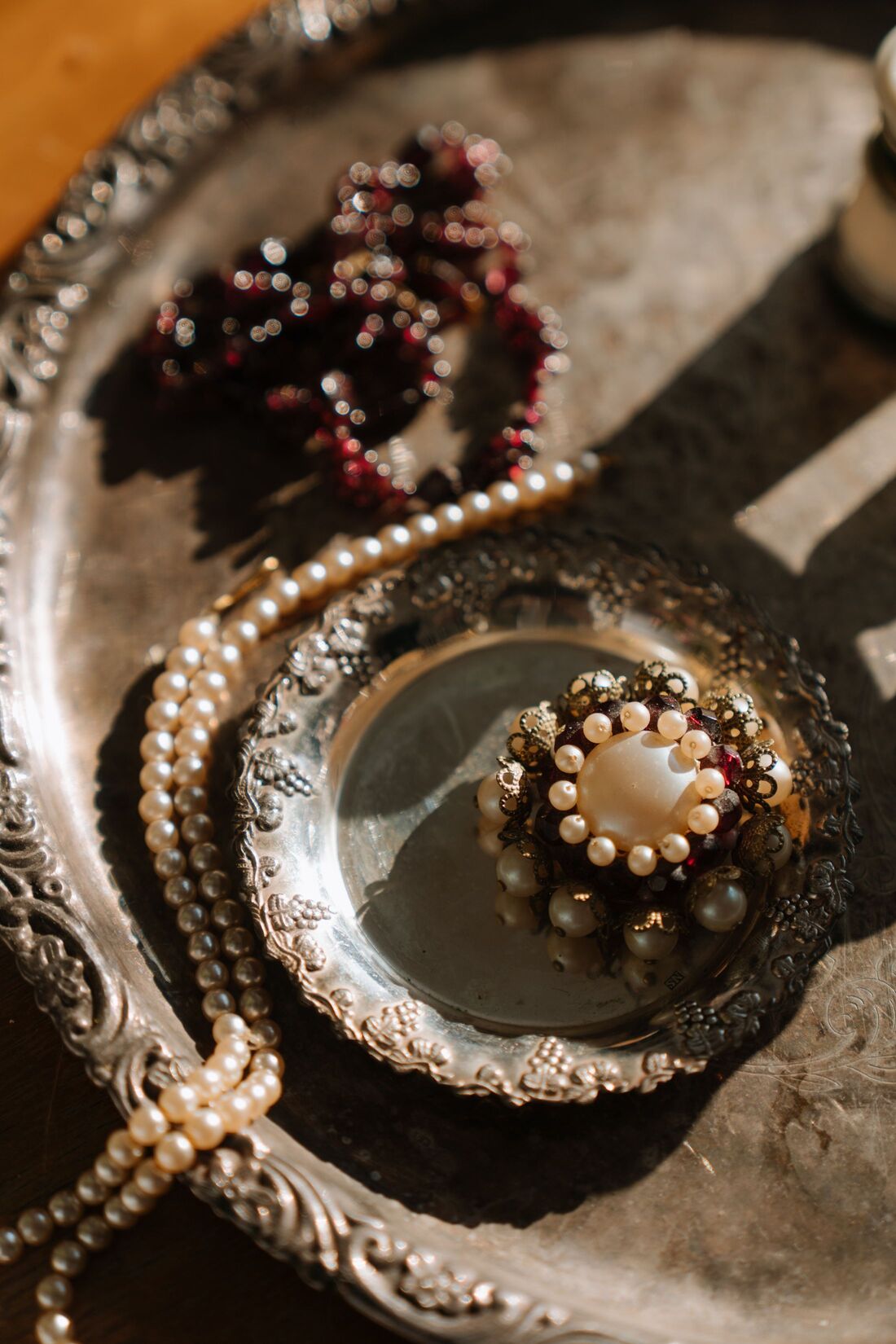 Broche ancienne et perles sur un plateau en argent